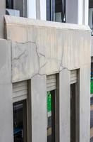 A close-up view of the concrete wall background shows the cracks of an old contemporary building. photo