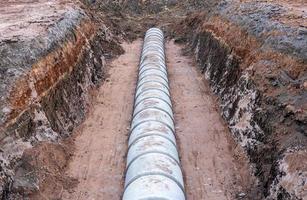 Large circular concrete sewer mounted in the ground awaiting a landfill. photo