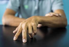 Close-up front view of both hands of a thai man wearing gray shirt making various gestures. photo