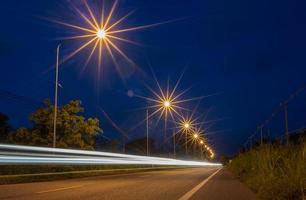 vista de ángulo bajo de las luces del camión y la luz de las estrellas de los postes de luz de la carretera debido a una exposición prolongada. foto