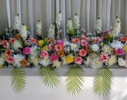 Close-up view of rows of white bouquets, roses and chrysanthemums of various colors. photo