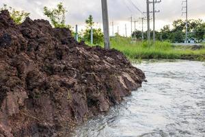 The view of the water rushing through the mounds of soil that have been dug up. photo