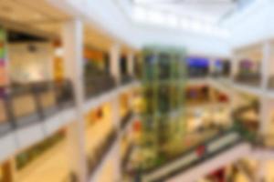 Blurred background of shopping mall center. People shopping in department store. photo