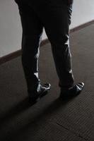 hombre de negro parado en una habitación con sombra foto