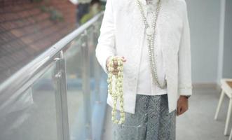 Beautiful Groom Holding Jasmine and Magnolia Flower Necklace for a Traditional Wedding Ceremony in Indonesia photo