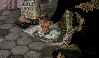 la novia lava los pies del novio en la ceremonia de boda tradicional foto