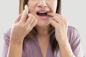 Woman flossing teeth with dental floss photo