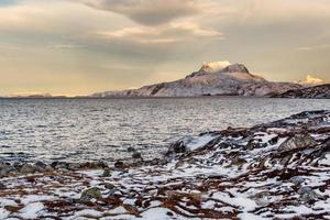 paisaje de tundra congelada con el frío mar groenlandés y la montaña sermitsiaq nevada en el fondo, cerca de la ciudad de nuuk, groenlandia