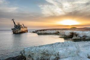 Abandoned rusty ship stranded ashore  in the sunset rays at Peyia village, Paphos photo