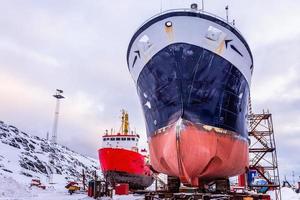 Fishing ships hulls in dockyard on maintenance during the winter time, port of Nuuk, Greenland photo
