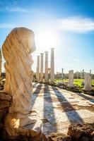 estatua de mármol bajo los rayos del sol y columnas antiguas en salamis, sitio arqueológico griego y romano, famagusta, chipre del norte
