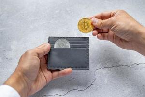 Close-up of hands holding a wallet with bitcoin coins. The concept of electronic decentralized money. photo