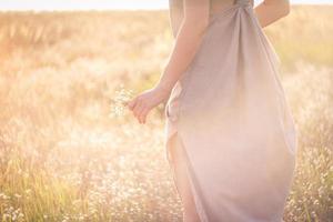 mujer de cerca con flores rodeada de luz solar deslumbrante foto conceptual