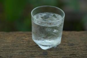 vaso de agua en el piso de madera foto