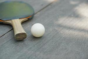 bucles de tenis de mesa y raqueta en mesa de madera foto