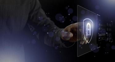 cyber security internet and networking concept. Businessman hand working with VR screen padlock icon on computer background photo