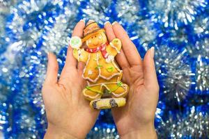 Colorful gingerbread man in female hands photo