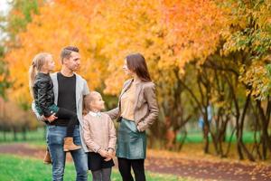 retrato de familia feliz de cuatro en día de otoño foto