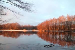 paisaje invernal junto al río tranquilo, hora dorada. foto