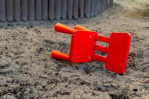 una pequeña silla roja en una caja de arena foto