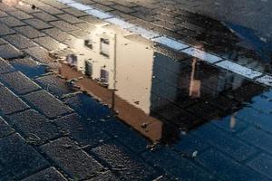 puddle in which an apartment building is reflected photo