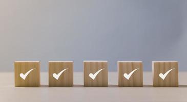 Checklist Survey and assessment concept, Checkmark icon on wooden blocks, gray background with copy space photo