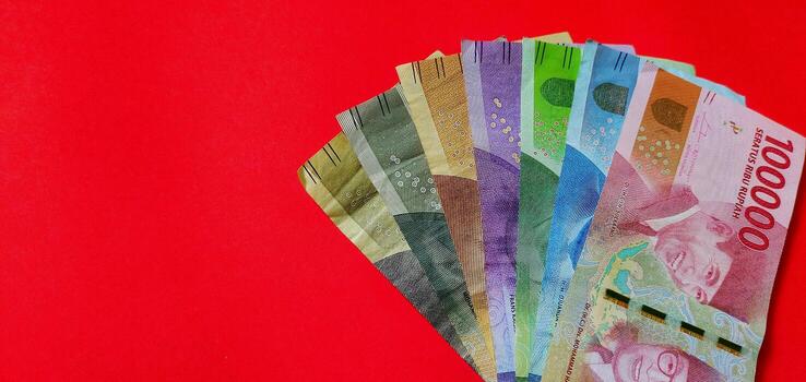 Indonesian Rupiah. Collection of banknotes Indonesian rupiah isolated on red background. photo