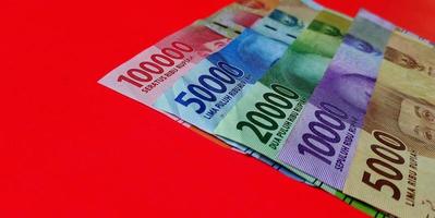 Close up view of 5.000 to 100.000 Indonesian Rupiah. Collection of banknotes Indonesian rupiah isolated on red background. photo