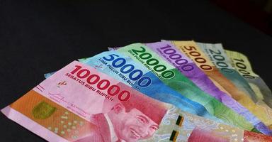 vista cercana de la rupia indonesia. colección de billetes rupia indonesia aislado sobre fondo negro. foto