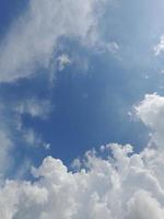 hermosas nubes blancas sobre fondo de cielo azul profundo. grandes nubes esponjosas suaves y brillantes cubren todo el cielo azul. foto