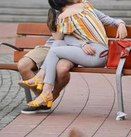 two young lovers resting on a bench on the street photo