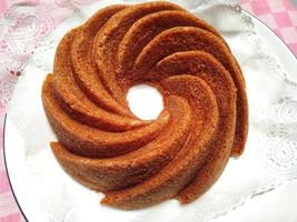 Homemade  round brown chocolate cake on white plate. close up food cinnamon cake photo