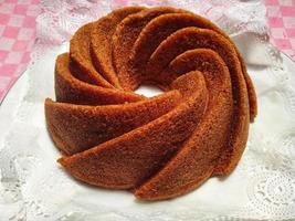 Homemade  round brown chocolate cake on white plate. close up food cinnamon cake photo