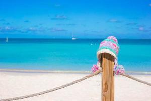 Closeup warm knitted cap on fence at tropical beach photo