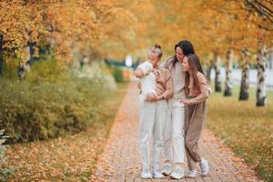 Little girl with mom outdoors in park at autumn day photo