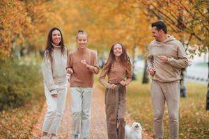 Portrait of happy family of four in autumn day photo