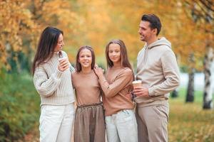 Portrait of happy family of four in autumn day photo