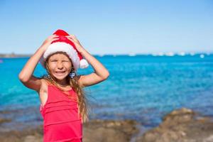 Cool beautiful little girl in Santa hat very happy photo