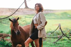 Young woman with wild horse outdoors photo