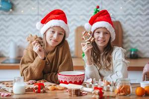 niñas pequeñas preparando pan de jengibre navideño en casa foto