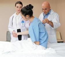 Doctors and woman patient discussion about medicine in hospital. Medical expertise person standing together in hospital ward room confidence talking. Professional healthcare nurse working with doctor photo