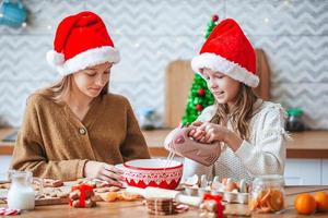 niñas pequeñas preparando pan de jengibre navideño en casa foto