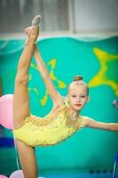 pequeña y hermosa gimnasta activa en competiciones de gimnasia rítmica foto