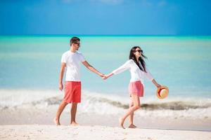 Young couple on white beach. Happy family on honeymoon vacation photo