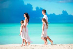 Young family walking on white tropical caribbean beach photo