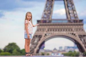 Adorable toddler girl in Paris background the Eiffel tower during summer vacation photo