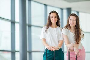 Young tourist women with baggage in international airport walking with her luggage. Airline passengers in an airport lounge waiting for flight aircraft photo