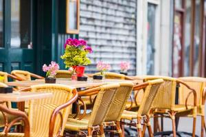 Outdoor cafe on a street of typical greek traditional village in Greece. Coffee on table for breakfast photo