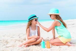 Kids applying sun cream to each other on the beach. The concept of protection from ultraviolet radiation photo