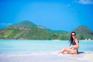 Young beautiful woman having fun on tropical seashore. Happy girl on white sand tropical beach photo